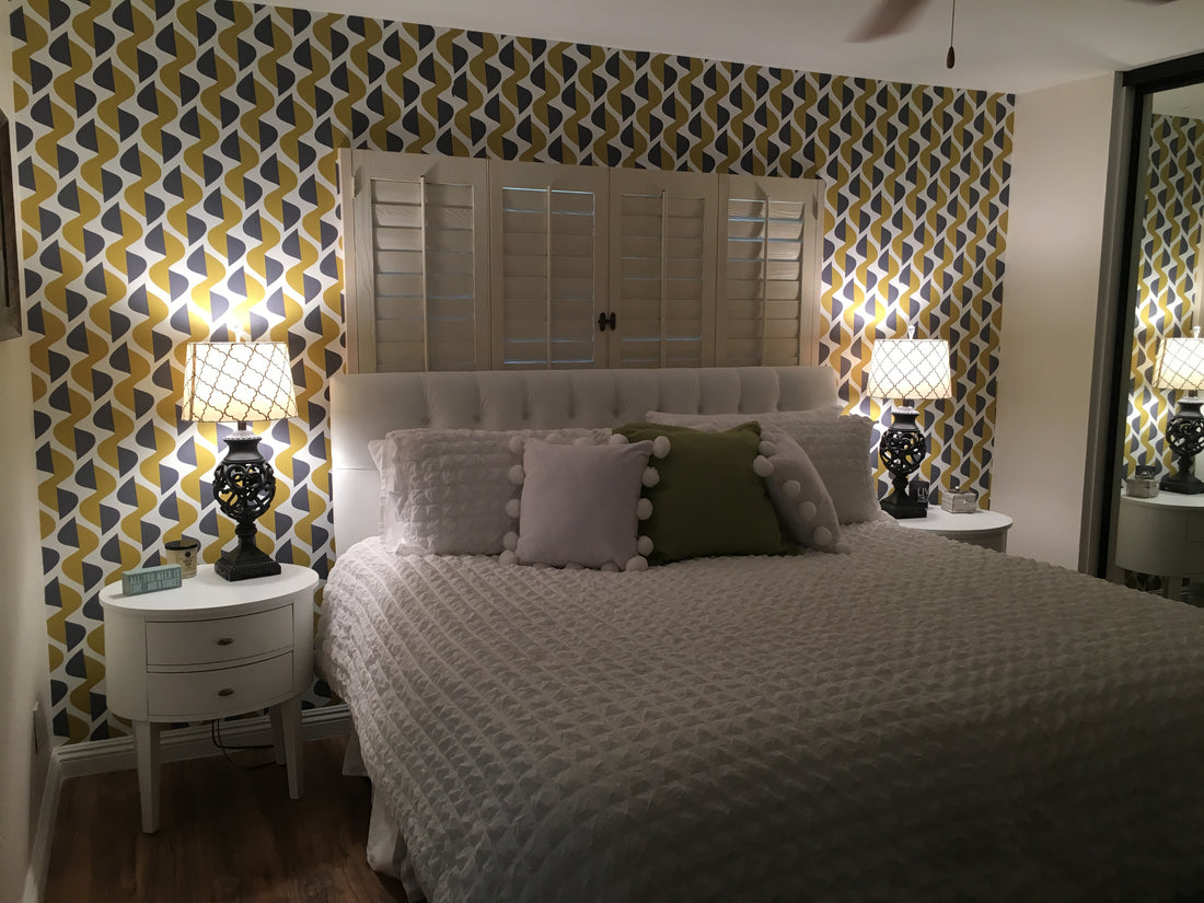 well-lit room with pastel chair and green-white striped wallpaper on accent wall